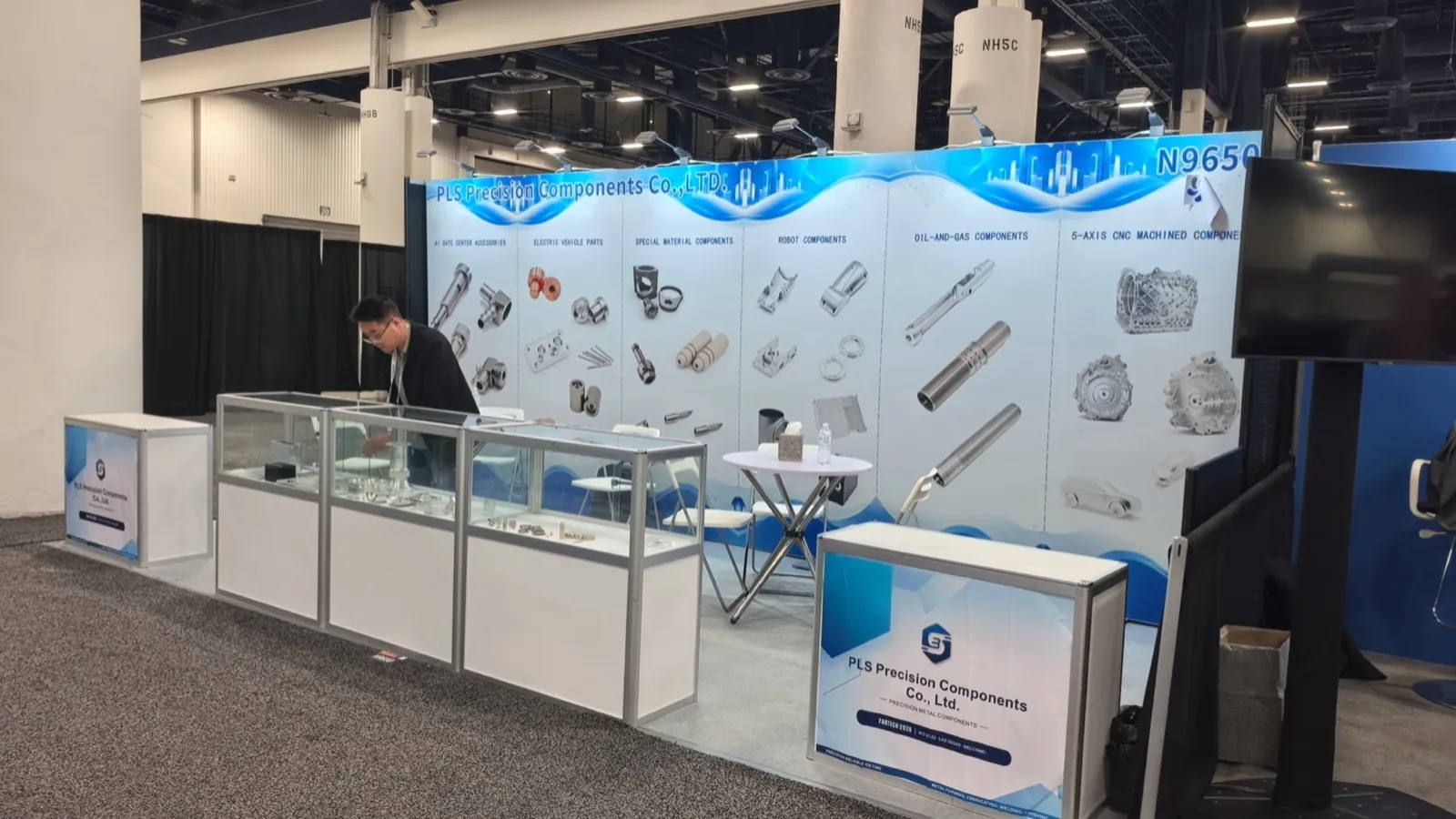 جناح PLS Precision Components في معرض FABTECH 2026 بمركز لاس فيغاس للمؤتمرات، مع جدار فئات المنتجات وخزائن العرض الزجاجية